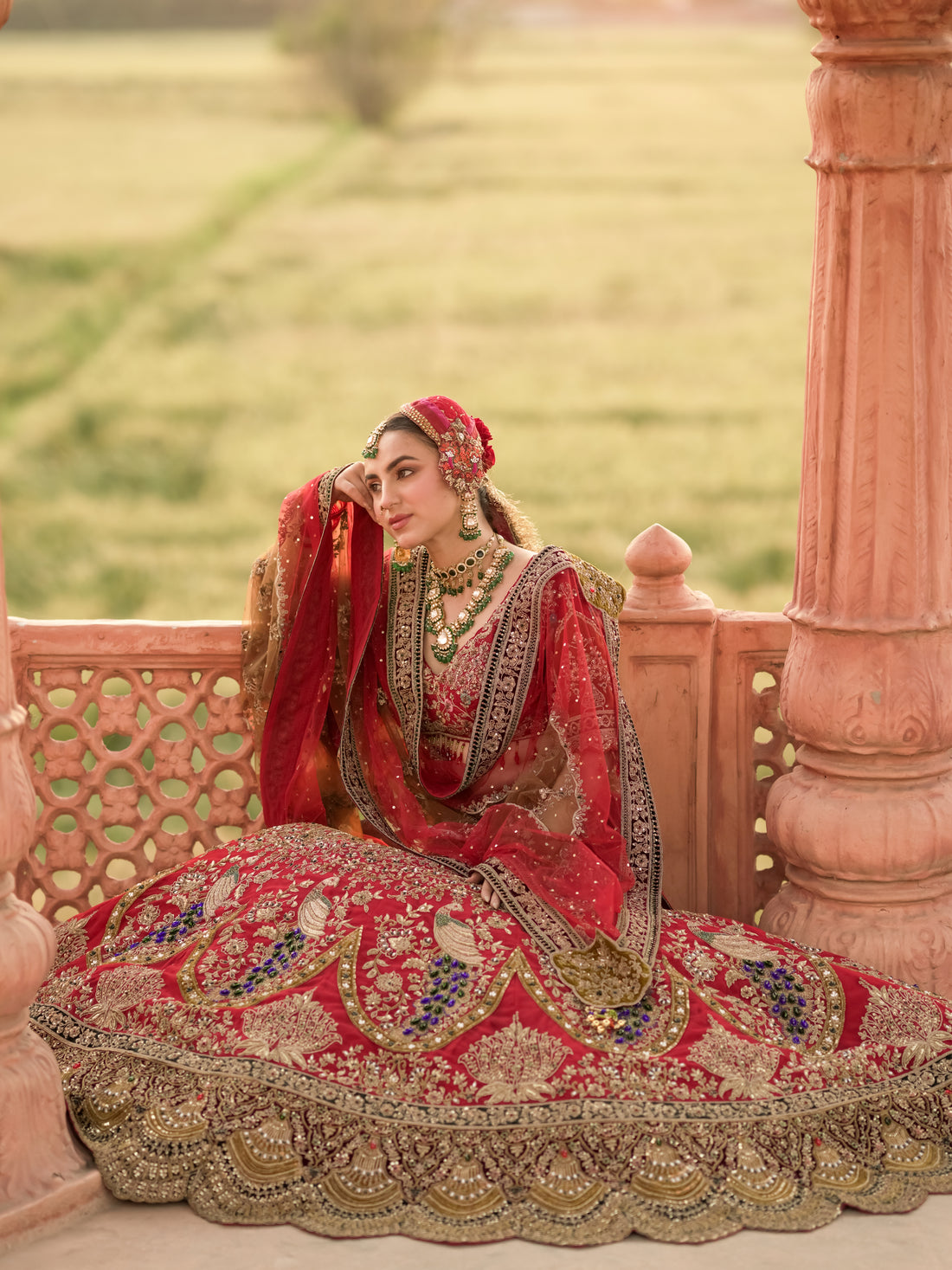 Layered sheer dupatta with antique-gold detailing on red bridal lehenga